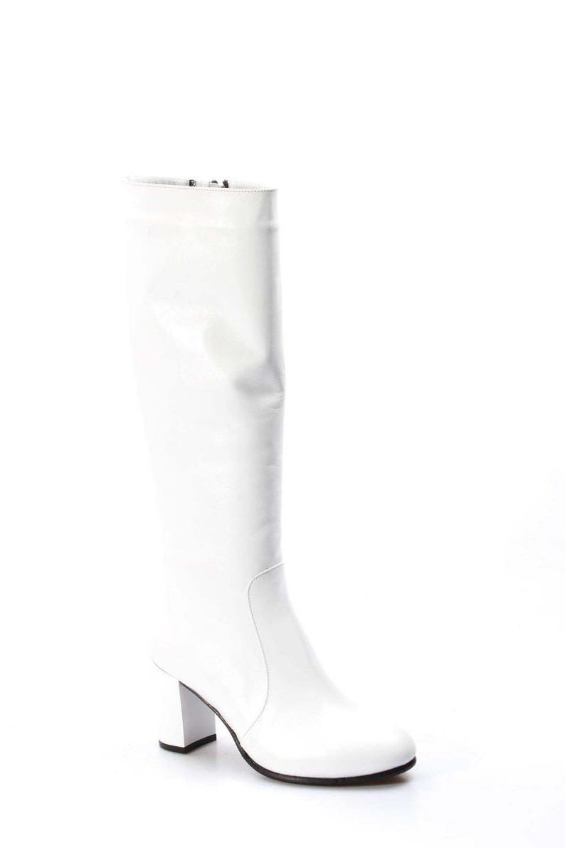 May include: White leather knee-high boots with a block heel.