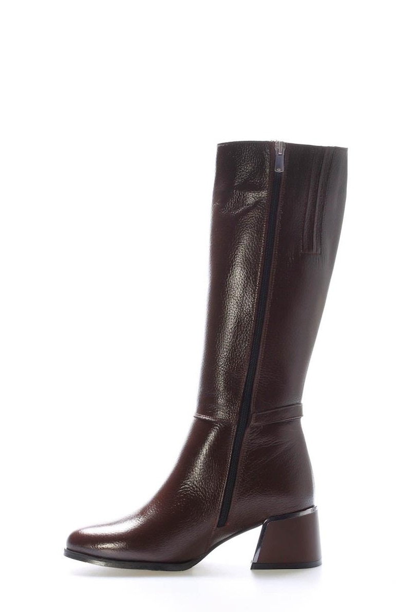 May include: A tall, brown leather boot with a side zip. The boot features a block heel and a textured finish. The zip runs along the side. The boot is approximately 35.5 cm tall.