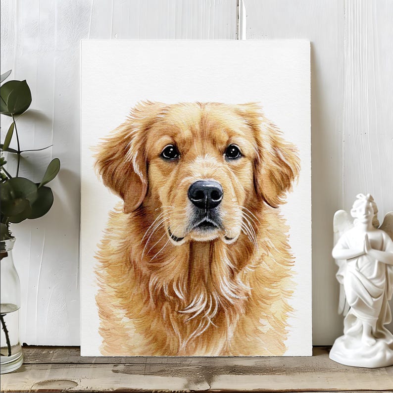 Op de afbeelding: Een aquarel schilderij van een Golden Retriever hond. De hond heeft een lichtbruine vacht, een zwarte neus en donkere ogen. Het kunstwerk wordt getoond op een witte achtergrond, met een klein engelenbeeld en groen.