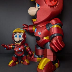 May include: Two red and gold action figures, one large and one small, resembling Mario in Iron Man armor. The figures have blue eyes and white noses. The larger figure is approximately 12 inches tall, while the smaller one is about 6 inches.