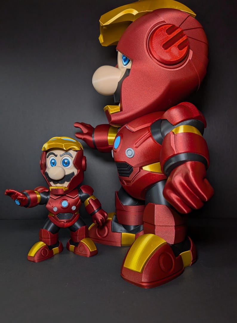 May include: Two red and gold action figures, one large and one small, resembling Mario in Iron Man armor. The figures have blue eyes and white noses. The larger figure is approximately 12 inches tall, while the smaller one is about 6 inches.