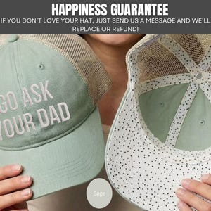 K&ouml;nnte beinhalten: Hellgr&uuml;ne Trucker-Cap mit dem gestickten Text "GO ASK YOUR DAD". Die Kappe hat einen Mesh-R&uuml;cken und einen gebogenen Schirm. Das Innenfutter ist wei&szlig; mit schwarzen Punkten. Der Text "HAPPINESS GUARANTEE" steht oben.