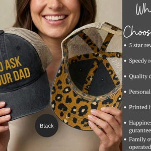 K&ouml;nnte beinhalten: Schwarze Trucker-M&uuml;tze mit dem Text "GO ASK YOUR DAD" in goldfarbenen Buchstaben. Die M&uuml;tze hat einen Mesh-R&uuml;cken und ein Leopardenmuster auf der Unterseite des Schirms. Eine Person h&auml;lt die M&uuml;tze.
