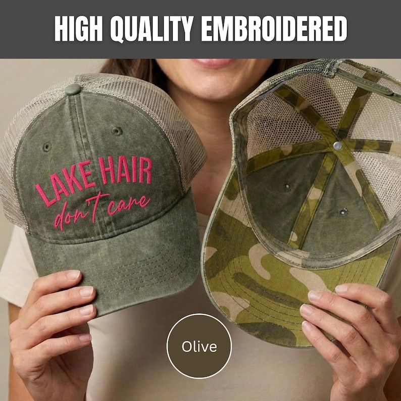 May include: An olive green trucker hat with a mesh back and the embroidered pink text "LAKE HAIR don't care" on the front, alongside a second trucker hat featuring a camouflage pattern on the brim and interior panels with a mesh back.