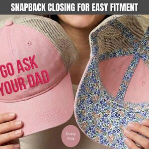 K&ouml;nnte beinhalten: Staubrosa Trucker-Cap mit dem Text "GO ASK YOUR DAD" in dunklerem Rosa gestickt. Die Kappe hat eine Mesh-R&uuml;ckseite und ein Innenfutter mit Blumenmuster. Der Snapback-Verschluss erm&ouml;glicht eine einfache Anpassung.