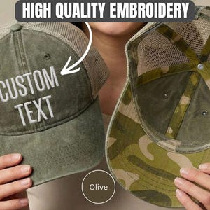 May include: An olive green trucker hat with a mesh back and a solid front panel featuring the embroidered text CUSTOM TEXT. A second hat is shown from the inside, displaying a camouflage pattern on the inner lining and the mesh structure.
