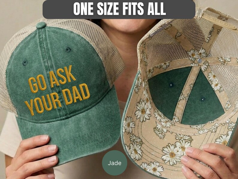 K&ouml;nnte beinhalten: Jadefarbene Trucker-Cap mit dem goldfarbenen Text "GO ASK YOUR DAD". Die Kappe hat einen Mesh-R&uuml;cken und ein Innenfutter mit G&auml;nsebl&uuml;mchenmuster. Der Text "ONE SIZE FITS ALL" befindet sich dar&uuml;ber.
