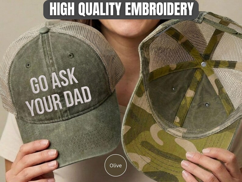 K&ouml;nnte beinhalten: Olivgr&uuml;ne Trucker-Cap mit dem wei&szlig;en gestickten Text "GO ASK YOUR DAD". Die Cap hat einen Mesh-R&uuml;cken und ein Camouflage-Muster auf der Unterseite des Schirms. Der Text "HIGH QUALITY EMBROIDERY" ist ebenfalls enthalten.