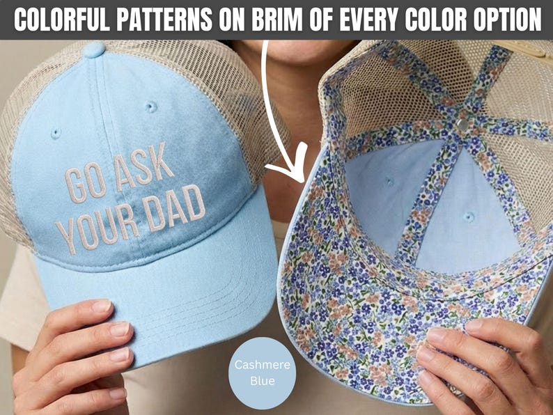 K&ouml;nnte beinhalten: Hellblaue Trucker-Cap mit dem Text "GO ASK YOUR DAD" in Wei&szlig; gestickt. Die Cap hat eine Mesh-R&uuml;ckseite und einen floral gemusterten Rand. Die Farbe ist mit "Cashmere Blue" gekennzeichnet.