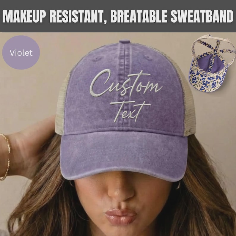 May include: A violet baseball cap with a mesh back and the words Custom Text embroidered in white script on the front. The cap features a makeup resistant, breathable sweatband and a separate view showing a blue and white floral interior pattern.