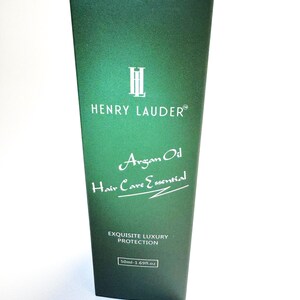 Puede incluir: Una botella verde con una etiqueta blanca que dice "Henry Lauder" y "Argan Oil Hair Care Essential". La etiqueta tambi&eacute;n dice "Exquisite Luxury Protection" y "50ml - 1.69fl.oz".