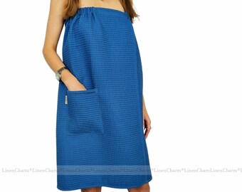 May include: A blue waffle weave bathrobe with a single pocket. The robe is made of linen and has a wrap-around style.