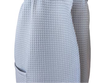 May include: A light gray waffle weave wrap skirt with a single pocket on the left side. The skirt has a tie closure and a wide elastic waistband.