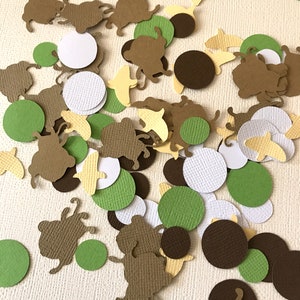 May include: A collection of brown, green, white, and yellow paper confetti. The confetti is in the shape of circles and small animals.