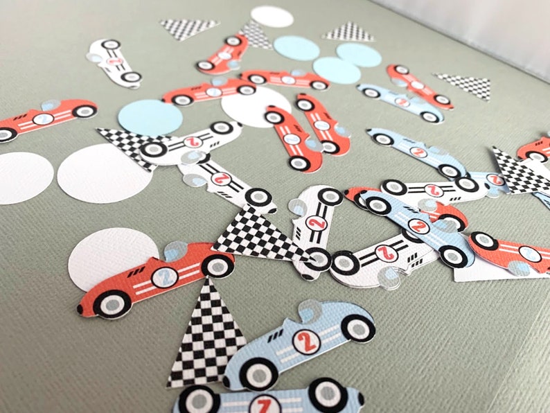 May include: A collection of red, blue, and white race car confetti. The confetti features checkered flags, circles, and race cars with the number 2 on them.