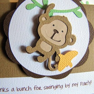 May include: A brown card with a white circle in the center. The circle has a brown monkey with a yellow butterfly on a green vine. The text "Thanks a bunch for swinging by my party!" is at the bottom of the card.