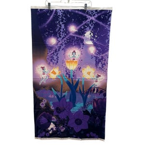 May include: A fabric panel featuring a whimsical fairy garden scene. The design includes fairies, flowers, and glowing orbs in shades of purple, blue, and yellow. The panel is suspended from a white hanger.