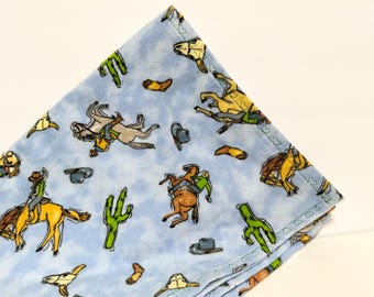 Manta de franela para bebé de 36', diseño de vaquero azul, una sola capa. Preencogida. Ribete decorativo de corazón verde.