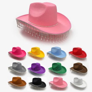May include: A collection of colorful cowboy hats. The hats come in various colors, including pink, yellow, blue, red, gray, purple, green, brown, black, and white. Each hat has a decorative rhinestone band and dangling fringe. The hats are a fun accessory.
