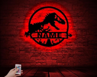 May include: A black metal silhouette of a dinosaur with a red glow behind it. The dinosaur is in a circle with the words "NAME" in the center. The silhouette is on a brick wall background.