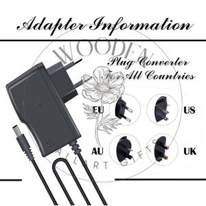 Puede incluir: Un adaptador de corriente negro con un cable negro y un convertidor de enchufe para todos los pa&iacute;ses. El adaptador tiene una etiqueta blanca con la letra "W" en ella. El convertidor de enchufe tiene diferentes tipos de enchufes para la UE, EE. UU., AU y el Reino Unido.