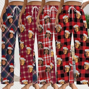 Pode incluir: Quatro pares de calças de pijama em vários padrões xadrez. Cada par apresenta um padrão repetido do rosto de uma pessoa usando um gorro de Papai Noel. As calças têm cintura com cordão e são em tons de vermelho, azul e bordô.