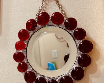 Mirror trimmed with ruby red glass.