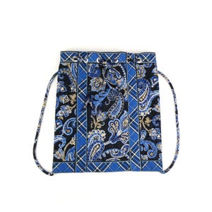 Può includere: Uno zaino blu con coulisse e motivo paisley su sfondo nero. La borsa presenta un motivo ripetuto di disegni paisley blu e beige. La borsa ha accenti a quadri blu e spallacci con coulisse blu.