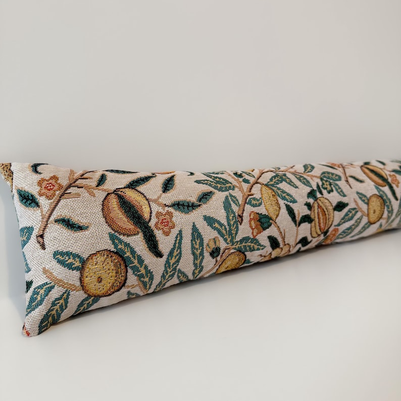 Peut inclure: Un long boudin de porte rectangulaire avec un fond beige et un motif r&eacute;p&eacute;t&eacute; d'oranges, de feuilles vertes et de petites fleurs orange. Le tissu a une texture tiss&eacute;e.