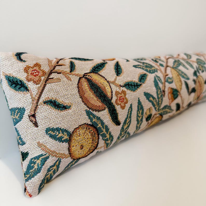 Peut inclure: Un long coussin rectangulaire avec une housse en tissu tiss&eacute;. Le coussin pr&eacute;sente un motif r&eacute;p&eacute;t&eacute; de grenades stylis&eacute;es, de feuilles et de fleurs dans des tons or, vert et marron sur un fond cr&egrave;me. Le design a une esth&eacute;tique botanique vintage.
