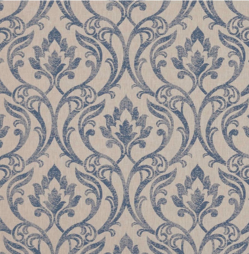 May include: A repeating pattern of blue floral damask designs on a beige background. The design features stylized flowers and scrolling vines, creating a classic and elegant look. The fabric has a textured appearance.