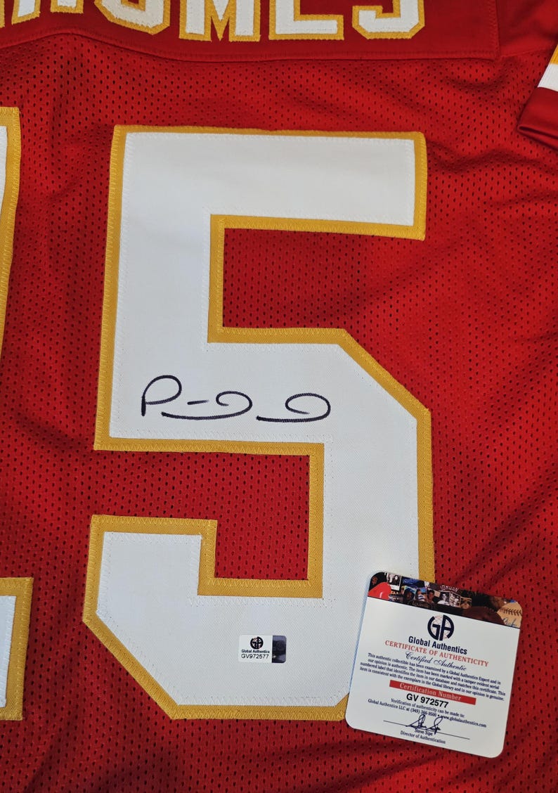May include: Red and white football jersey with the number 5 in white with gold trim. The jersey has a signature on the number 5. A Global Authentics certificate of authenticity is attached.
