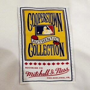 Puede incluir: Una etiqueta rectangular con las palabras "COOPERSTOWN AUTHENTIC COLLECTION" en letras azul marino y rojo. La etiqueta es amarilla con un logotipo de b&eacute;isbol rojo y azul. La marca "Mitchell & Ness" est&aacute; en escritura roja.