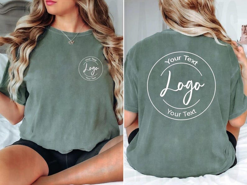 Puede incluir: Una camiseta de manga corta color verde salvia con un gr&aacute;fico circular blanco en el pecho izquierdo y una versi&oacute;n m&aacute;s grande del mismo gr&aacute;fico en la espalda. El gr&aacute;fico contiene el texto Your Text, Logo y Your Text en fuente blanca.