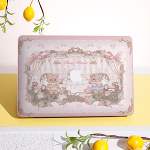 May include: A pink laptop case with a whimsical design featuring teddy bears, floral accents, and the text "Honey Winnie." The case has a decorative border and a light-coloured background, creating a charming aesthetic.