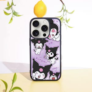 Può includere: Una custodia per telefono viola con illustrazioni di Kuromi, un personaggio in bianco e nero con un fiocco rosa. La custodia ha un bordo nero e un ritaglio per la fotocamera.