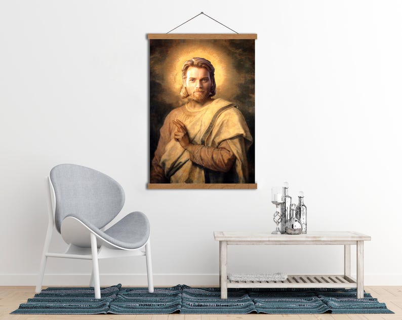 Może przedstawiać: Oprawiony portret mężczyzny z długimi włosami i aureolą, ubranego w kremową szatę. Grafika jest wyświetlana na drewnianej ramie do zawieszania. Tło ma ciepły, złoty odcień.