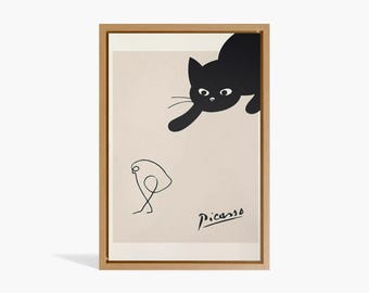 Może przedstawiać: Oprawiony wydruk artystyczny przedstawiający czarnego kota i minimalistyczny rysunek ptaka na beżowym tle. Widoczny podpis artysty "Picasso". Grafika prezentowana jest w drewnianej ramie.