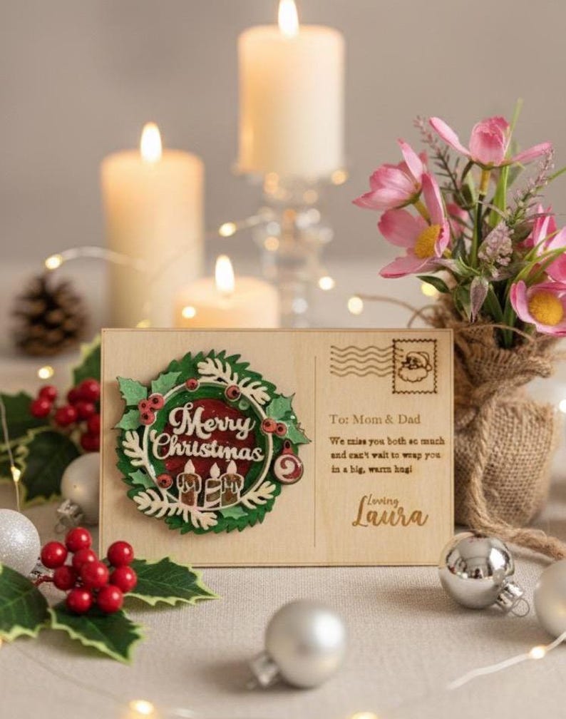 May include: A wooden Christmas postcard with a wreath design and the words "Merry Christmas." The postcard includes a message to Mom & Dad and is decorated with candles, ornaments, and flowers.