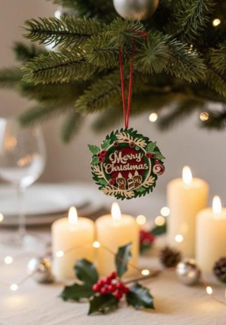 May include: A festive Christmas scene featuring a decorative ornament with "Merry Christmas" text, hanging from a pine branch. Lit candles and holiday decor, including berries and pinecones, create a warm, inviting atmosphere.