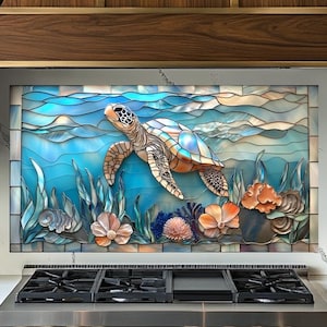 May include: A stained glass kitchen backsplash featuring a sea turtle swimming in a vibrant blue ocean scene. The artwork includes coral, seaweed, and flowers in shades of orange, pink, and blue. The backsplash is installed above a stainless steel gas range.