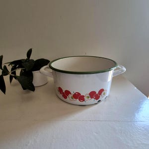 May include: A white ceramic mug with a black handle and the text "But First, Coffee" in a black, bold font. The mug is sitting on a white surface. The mug is approximately 4 inches tall.