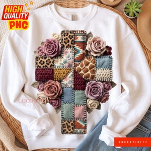 May include: White sweatshirt featuring a cross design made of patchwork squares with floral and animal print patterns. The cross is adorned with mauve roses and green leaves. The text "HIGH QUALITY PNG" is in the upper left corner.