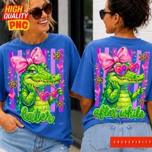 May include: Blue t-shirts with a cartoon alligator wearing heart-shaped sunglasses and a pink bow. The front of the shirt says "later" in green script, and the back says "after while". The design includes purple stripes, leopard print stars, and hearts.