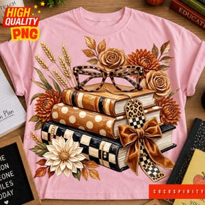 Op de afbeelding: Een lichtroze t-shirt met een afbeelding van drie gestapelde boeken versierd met een bril met luipaardprint, herfstkleurige bloemen, korenaren en een grote bruine strik met een luipaard- en ruitpatroon aan het bovenste boek.