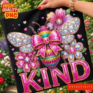 May include: Black graphic tee featuring a bejeweled bee with a pink bow, surrounded by flowers and the word "KIND". The design includes the text "HIGH QUALITY PNG" in the upper left corner and "COCOSPIRITY" in the lower right corner.