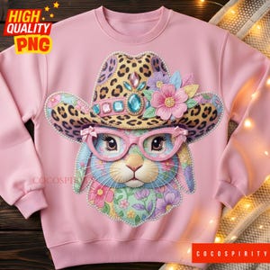 May include: Pink sweatshirt featuring a whimsical bunny wearing a leopard print cowboy hat, pink glasses, and floral accents. The bunny's face is adorned with colorful floral patterns. The words "HIGH QUALITY PNG" are in the upper left corner.