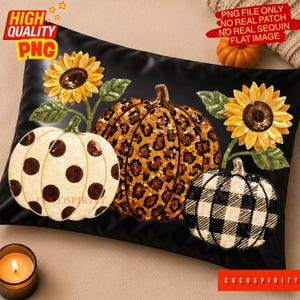 Puede incluir: Un cojín rectangular negro con un diseño de lentejuelas de tres calabazas y dos girasoles. La calabaza izquierda es blanca con lunares marrones, la central es naranja con estampado de leopardo y la derecha es blanca con cuadros negros.
