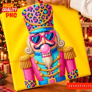 Può includere: Un'illustrazione di uno schiaccianoci su sfondo giallo brillante con un cappello a stampa leopardata rosa e blu, occhiali da sole a forma di cuore, una bolla di gomma da masticare rosa, baffi scuri e un'uniforme rosa e blu con cordoni dorati.