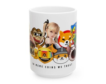 Peut inclure: Une tasse à café en céramique blanche avec un collage coloré de personnages de dessins animés et le texte "In Meme Coins We Trust".